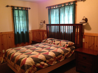 four-bedroom-bedroom a bedroom with a bed and a chair in a room