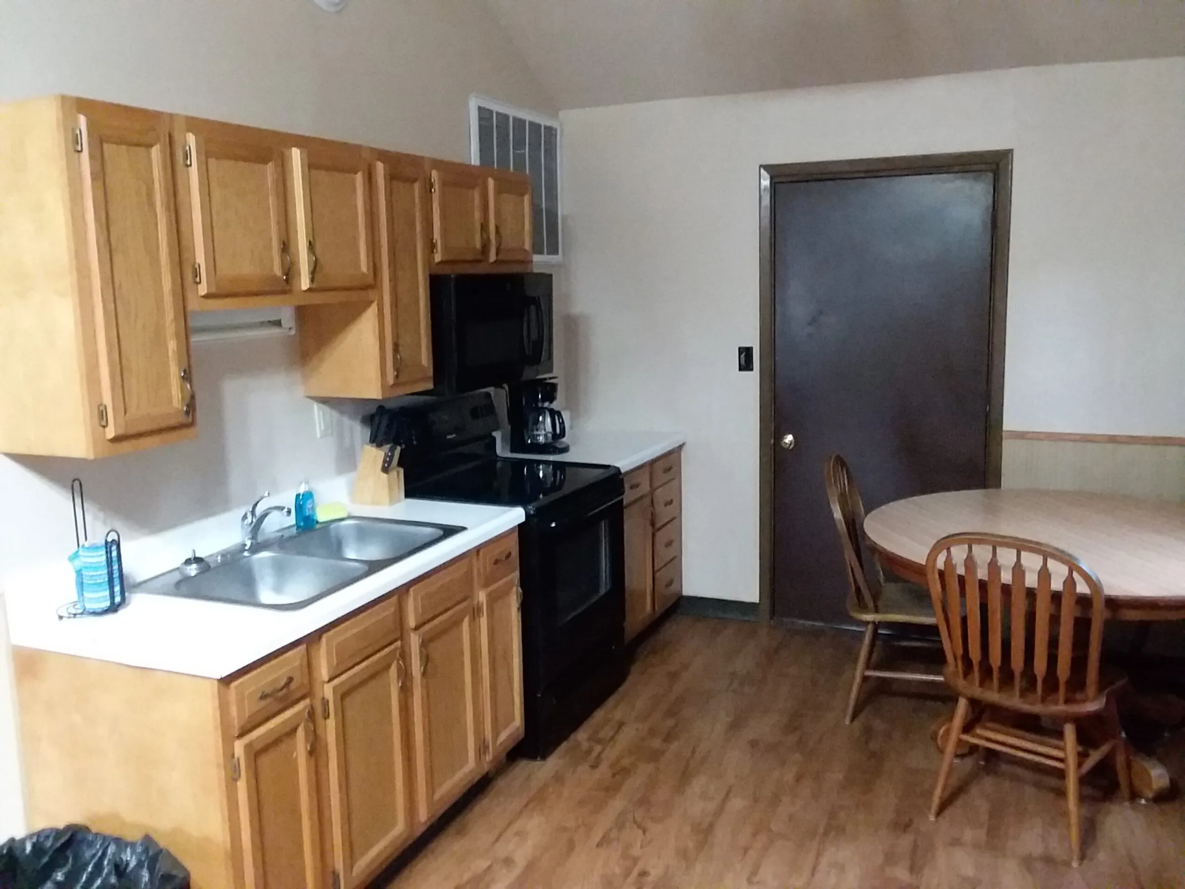 a kitchen with wooden cabinets and a dining room table