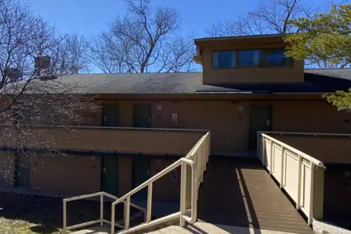 an empty park bench next to a building