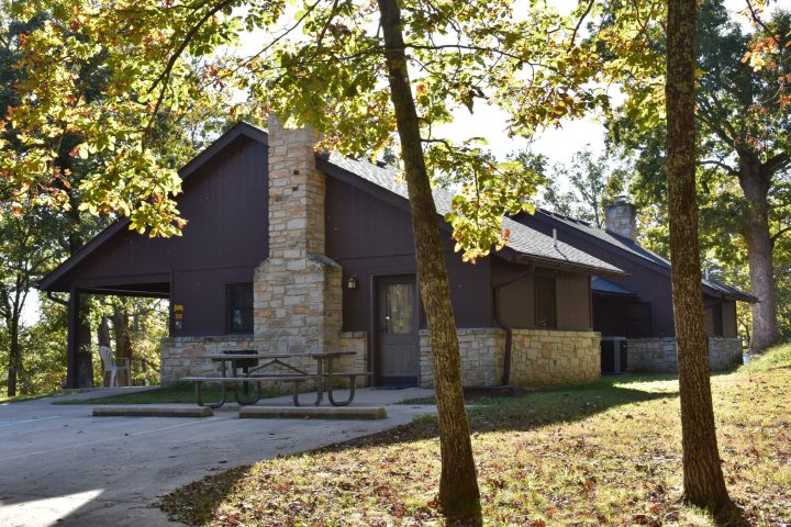 side of a cabin with picnic benches outside