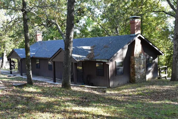 front of a cabin surrounded by trees
