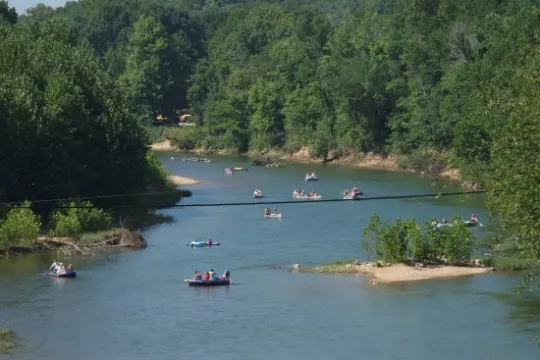 a boat floating along a river next to a body of water