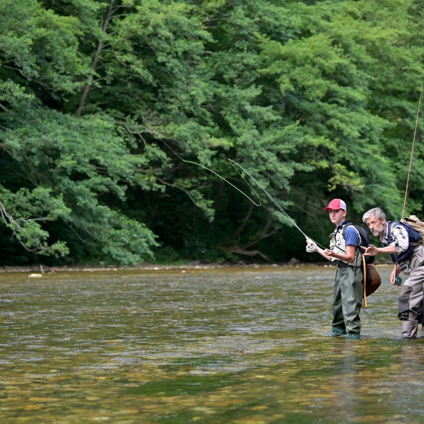 a man standing next to a body of water